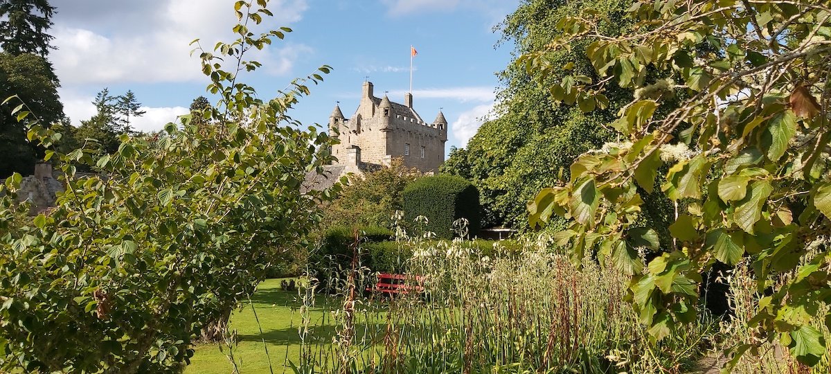 cawdor-castle-in-moray flowers from cawdor castle gardens looking at cawdor castle through the trees