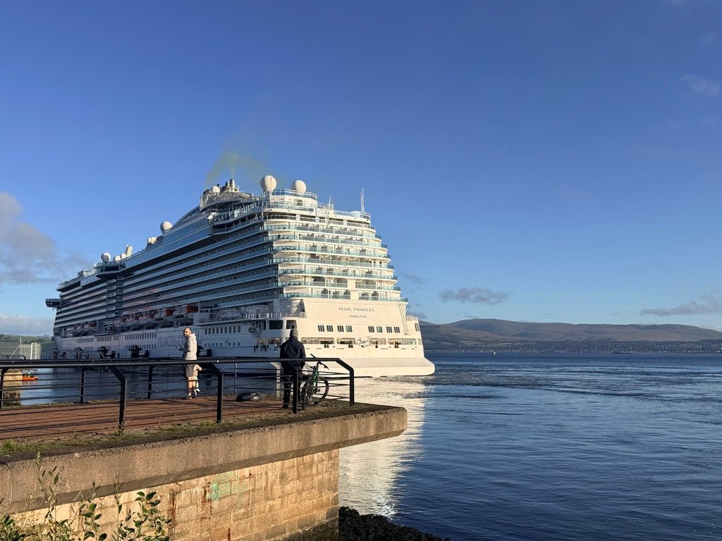 Regal Princess in the Firth of Clyde Cruise ship Regal Princess sailing on the water, viewed from a pier with people watching, hills in the background