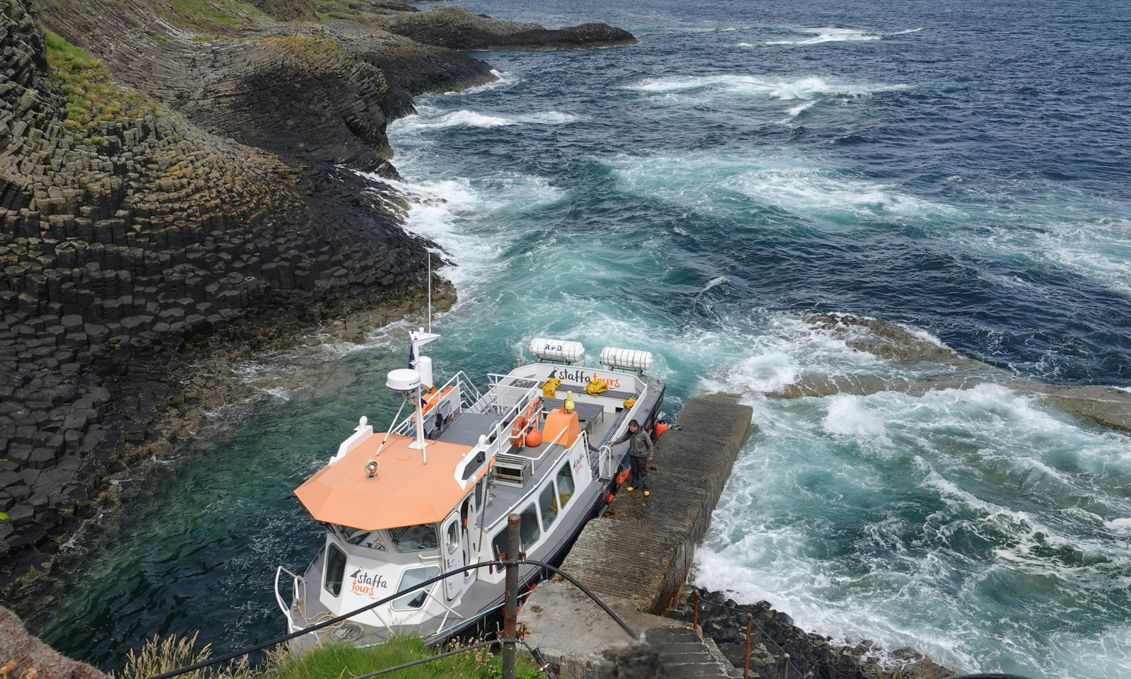 Boat Landing at Isle of Staffa's Basalt Columns Tour boat docked beside Staffa's hexagonal basalt columns, Scotland