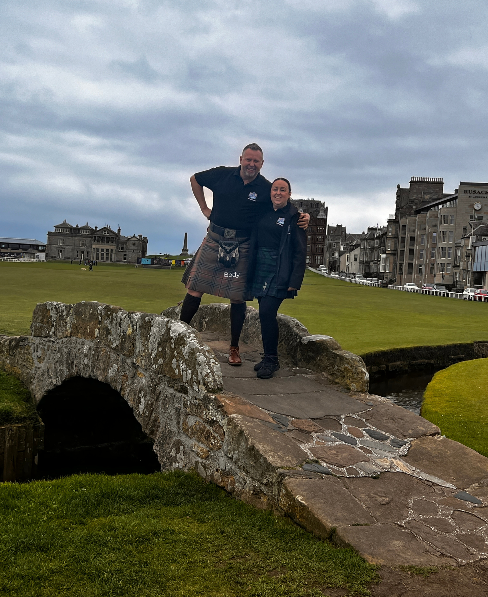 James & Lesley on the Swilcan Bridge Tour Guide Scotland's James & Lesley posing on the Swilcan Bridge at St Andrews, with the Old Course and town buildings behind