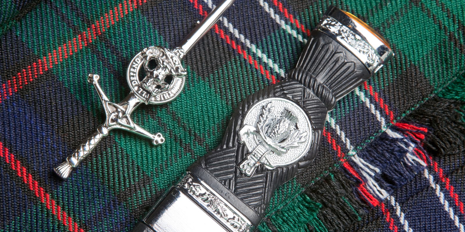 Clan kilt pin and sgian-dubh on tartan kilt fabric